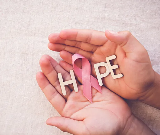 Open hands holding the word hope with a cancer ribbon