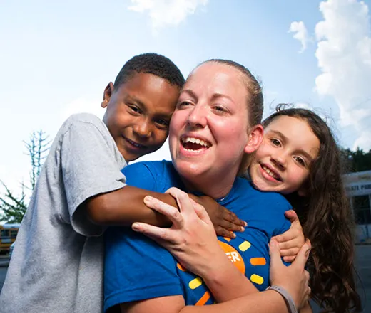 Camp kids hugging their counselor